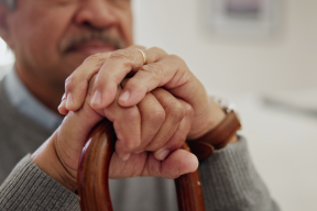 CATIE News Dec 17 - seated man holds a cane with both hands
